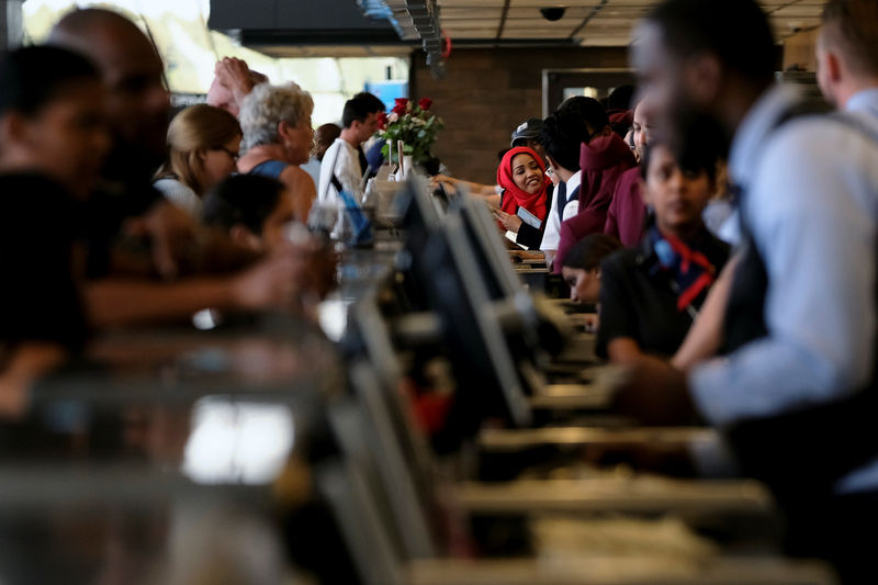 © Reuters. Airlines workers check passengers in for flights at the ticket counter at Dulles International Airport in Dulles, Virginia, U.S.