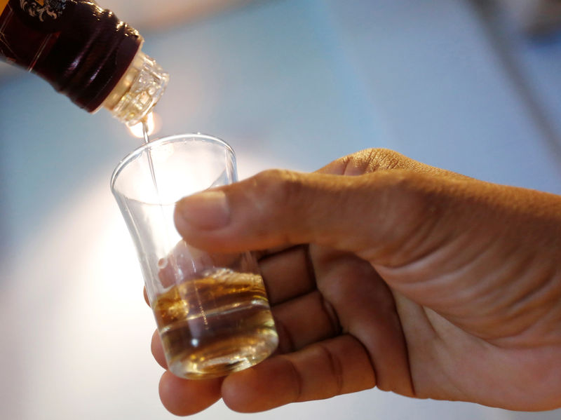 © Reuters. Imagen de archivo de un empleado sirviendo whisky en un vaso en un restaurante de Phnom Penh