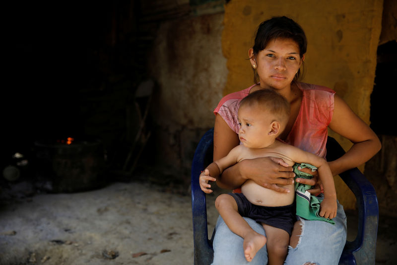 © Reuters. Foto de una madre venezolana con su bebé en la licalidad de San Francisco de Yare, Venezuela
