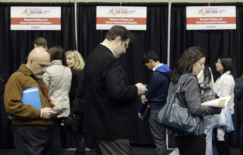 © Reuters. FILE PHOTO:  People wait in line for resume critique and career assessment sessions at the 2014 Spring National Job Fair and Training Expo in Toronto