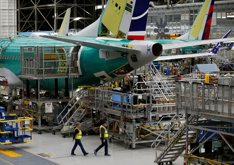 © Reuters. FILE PHOTO: Employees walk by the end of a 737 Max aircraft at the Boeing factory in Renton