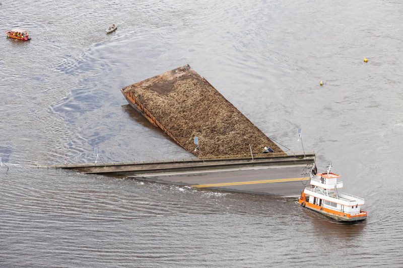 © Reuters. Un bote arrastra parte de un puente que colapsó en el río Moju, en la Carretera PA-483 en Acara, estado de Pará.