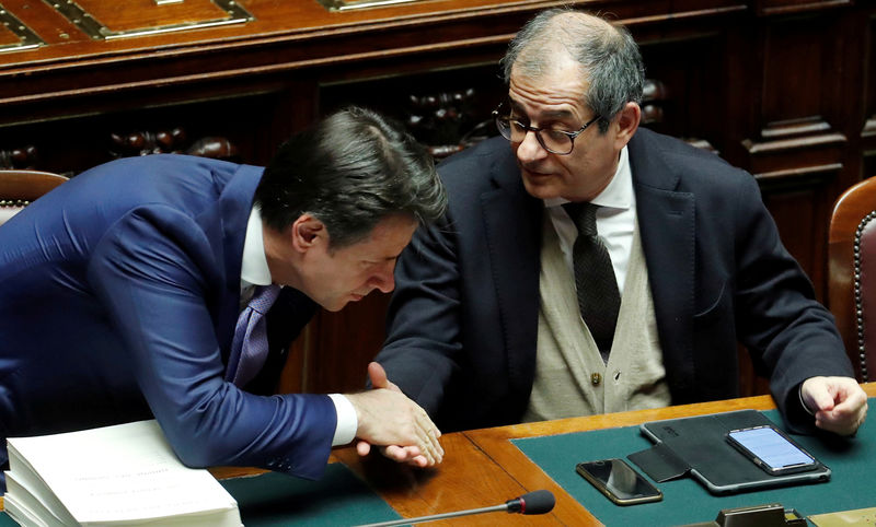 © Reuters. FILE PHOTO: Italian Prime Minister Giuseppe Conte and Italian Economy Minister Giovanni Tria shake hands during a final vote on Italy's 2019 budget law at the Lower House of the Parliament in Rome