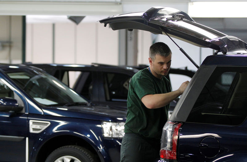 © Reuters. FILE PHOTO: Workers examine Land Rover Freelander vehicles as they come off the production line at Jaguar Land Rover's  Halewood assembly plant in Liverpool