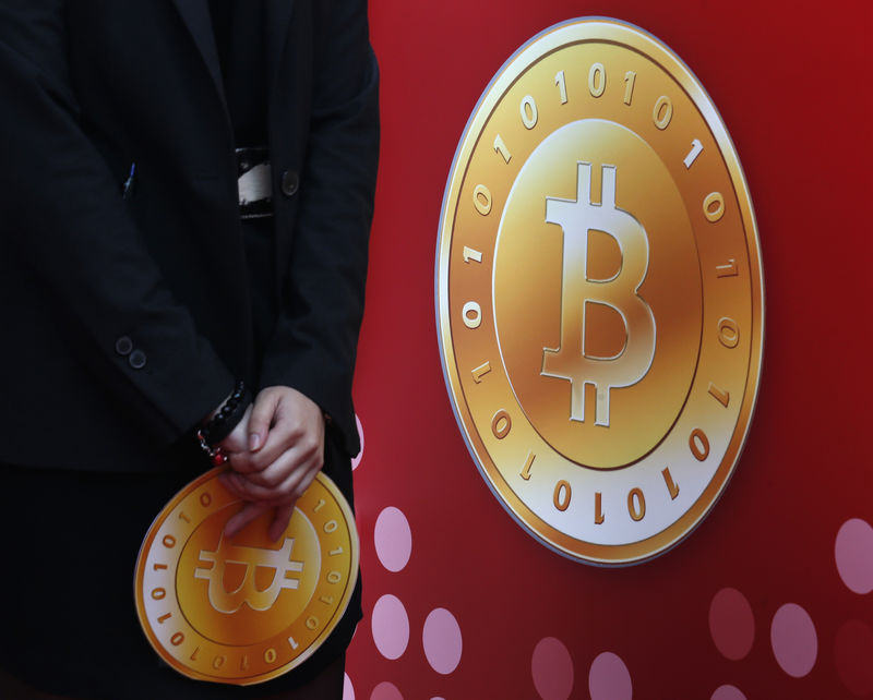 © Reuters. Attendant holds bitcoin sign during the opening of Hong Kong's first bitcoin retail store