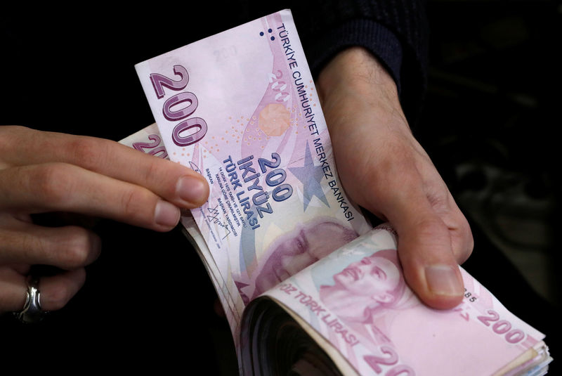 © Reuters. FILE PHOTO: A merchant counts Turkish lira banknotes at the Grand Bazaar in Istanbul