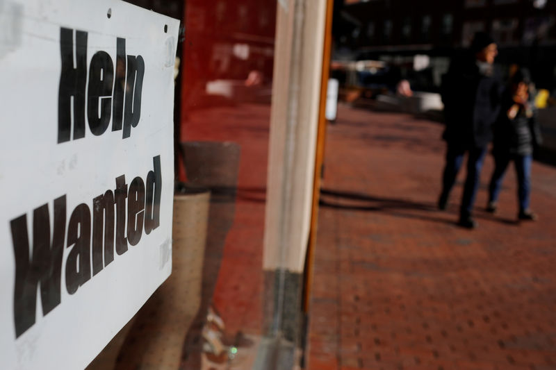 © Reuters. FILE PHOTO: A "Help Wanted" sign sits in the window of a shop in Harvard Square in Cambridge