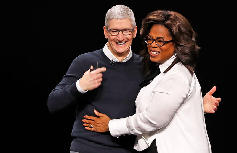 © Reuters. FILE PHOTO: Tim Cook, CEO of Apple and Oprah Winfrey hug during an Apple special event at the Steve Jobs Theater in Cupertino