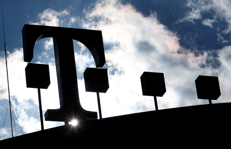 © Reuters. The logo of Deutsche Telekom AG is silhouetted against the sun and clouds atop of the headquarters of German telecommunications giant in Bonn