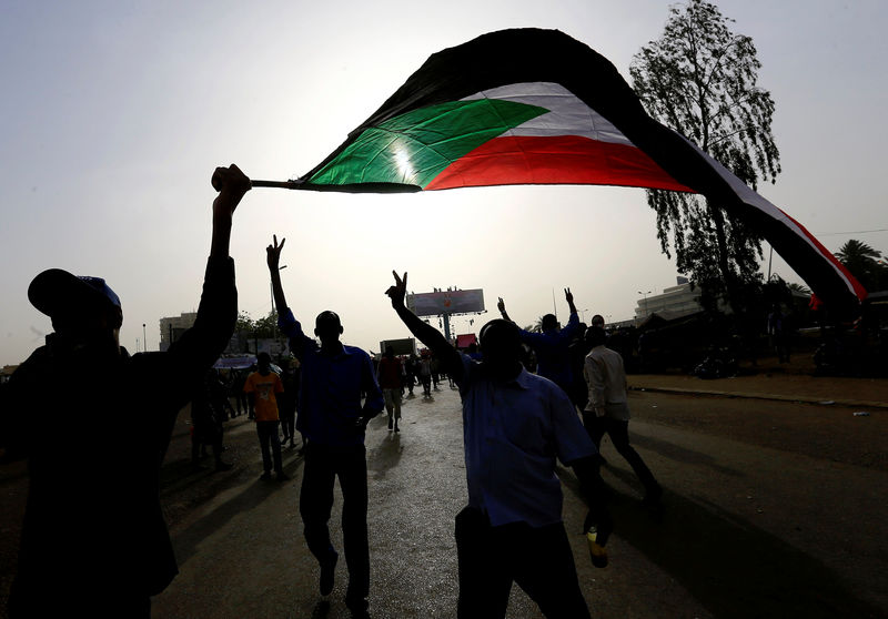 © Reuters. Los manifestantes sudaneses agitan su bandera nacional en una manifestación de protesta en Jartum