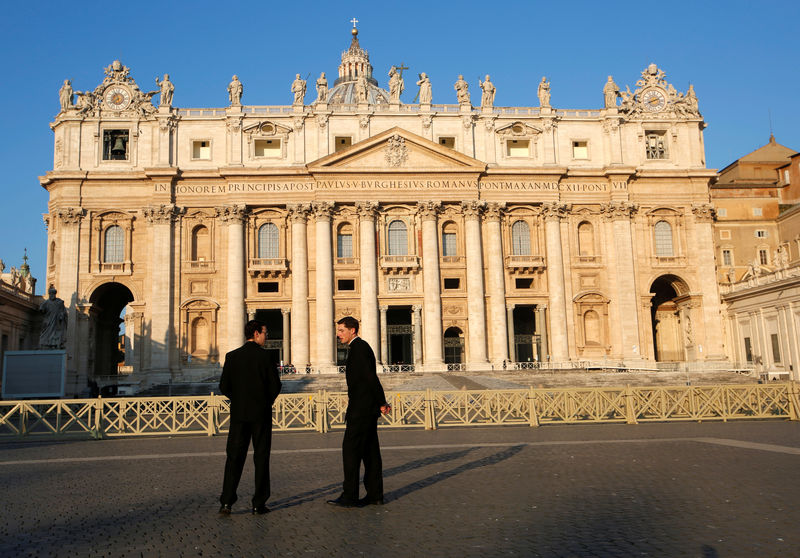 © Reuters. Foto de archivo. Dos hombres hablan en frente de la Basílica de San Pedro el primer día de la cumbre contra los abusos sexuales en la Iglesia, Vaticano