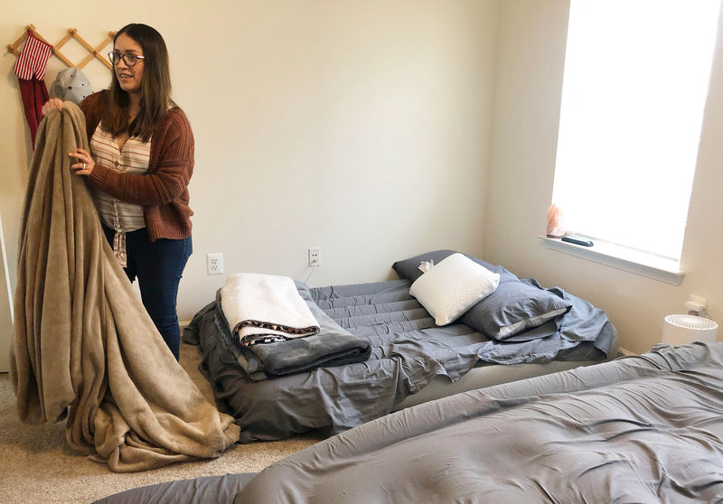 © Reuters. Sandra Buitrago folds bedding after her family was moved to a new home after enduring a two-year housing ordeal in Fort Meade