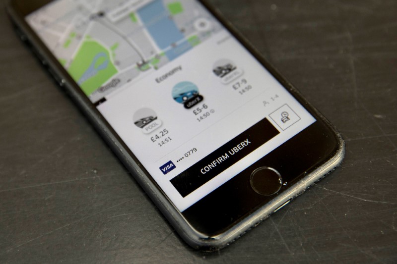 © Reuters. FILE PHOTO: A photo illustration shows the Uber app on a mobile telephone, as it is held up for a posed photograph, in London