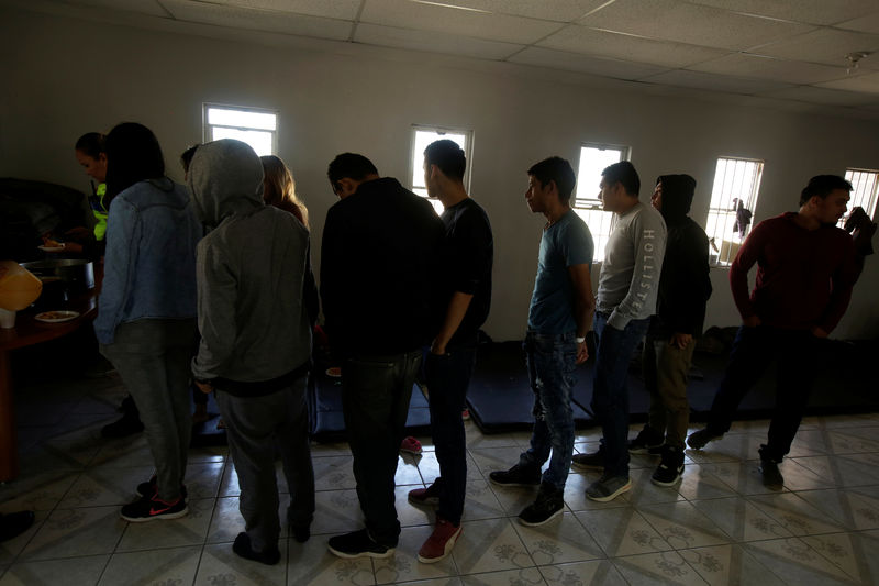 © Reuters. FILE PHOTO - Central American migrants, who are waiting for their court hearing for asylum seekers that returned to Mexico to await their legal proceedings under a new policy established by the U.S. government, queue for food in Ciudad Juarez