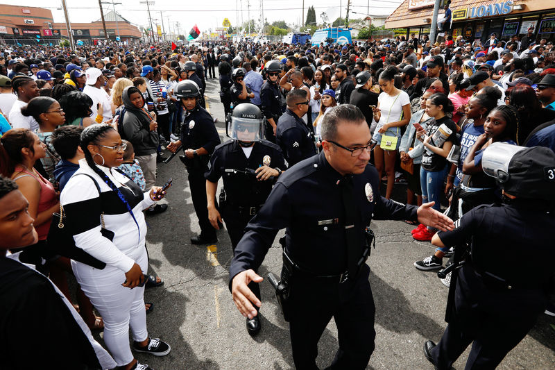 © Reuters. LAPD officers reopen a path for the funeral procession after fans filled the intersection while waiting for the procession following a memorial for rapper Nipsey Hussle in Los Angeles