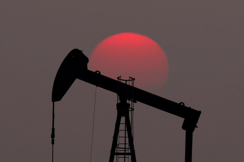 © Reuters. FILE PHOTO: The sun sets behind a pump-jack outside Saint-Fiacre