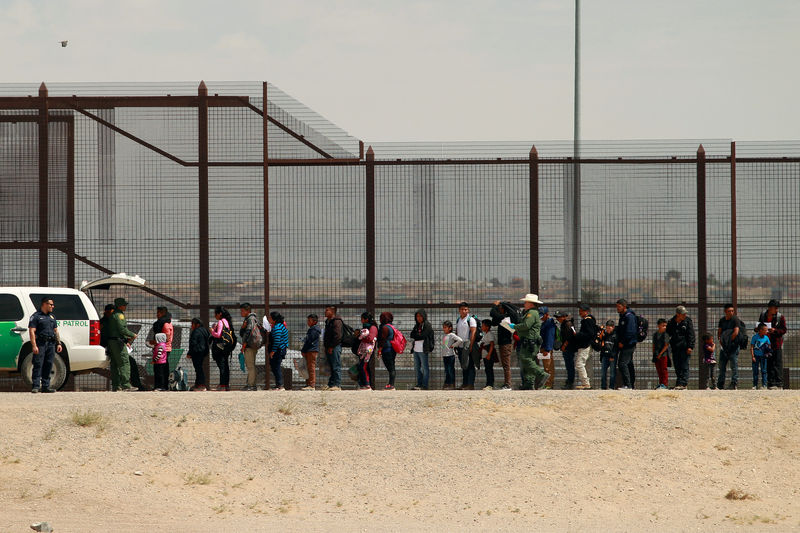 © Reuters. Migrants queue as they listen to U.S. Customs and Border Protection (CBP) officials after crossing illegally into the United States to request asylum, in El Paso, Texas, U.S., in this picture taken from Ciudad Juarez