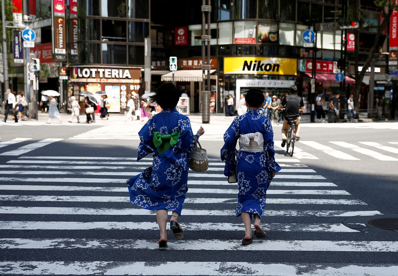 © Reuters. FILE PHOTO: Girls wearing the yukata, or casual summer kimono, run as they cross the road at a shopping district in Tokyo