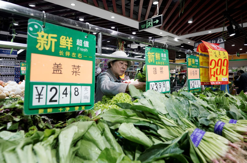 © Reuters. A woman selects vegetables at a supermarket in Beijing