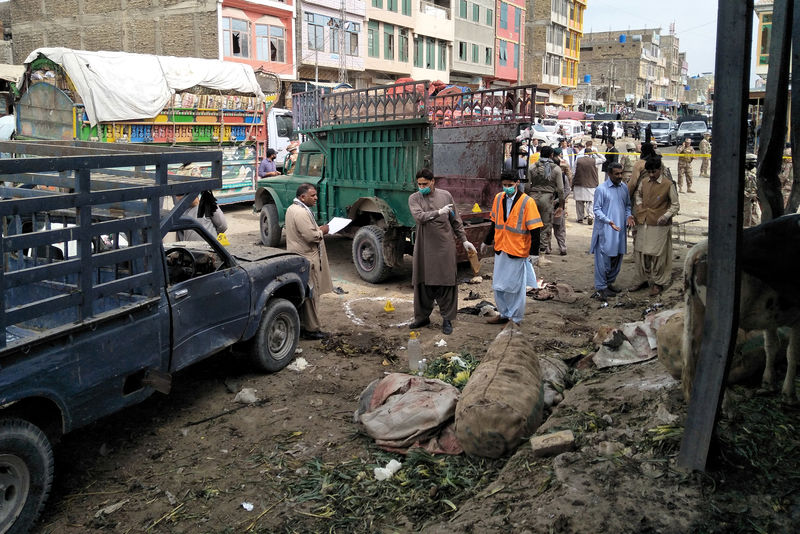 © Reuters. Miembros de la unidad de eliminación de bombas examinan el sitio después de una explosión en un mercado de verduras en Quetta