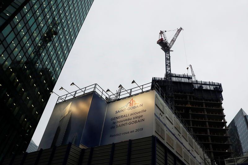 © Reuters. FILE PHOTO:  The logo of  Saint-Gobain is seen on a banner on a building construction site in the financial and business district of La Defense, outside Paris