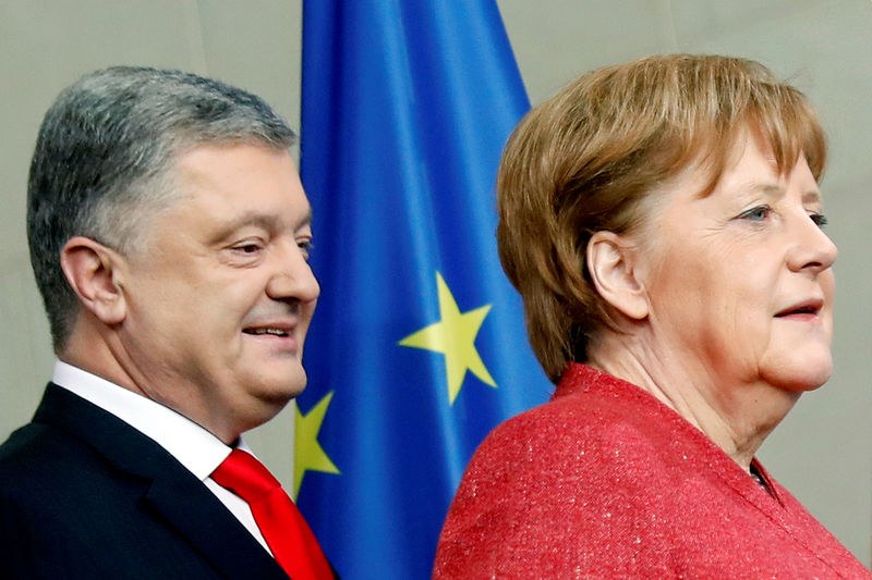 © Reuters. German Chancellor Angela Merkel and Ukrainian President Petro Poroshenko arrive for a joint news conference after their working lunch in Berlin