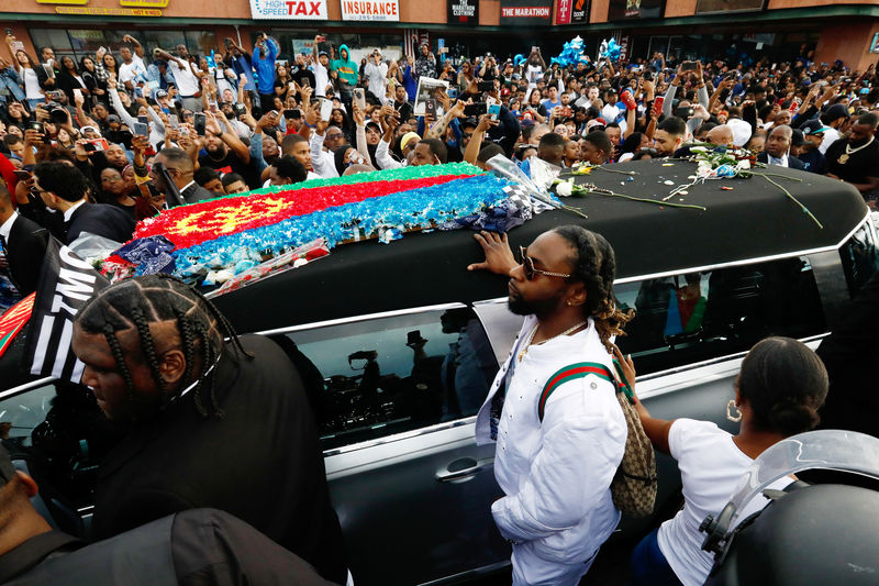 © Reuters. People watch the procession of a hearse of the late rapper Nipsey Hussle in front of The Marathon Clothing store in Los Angeles