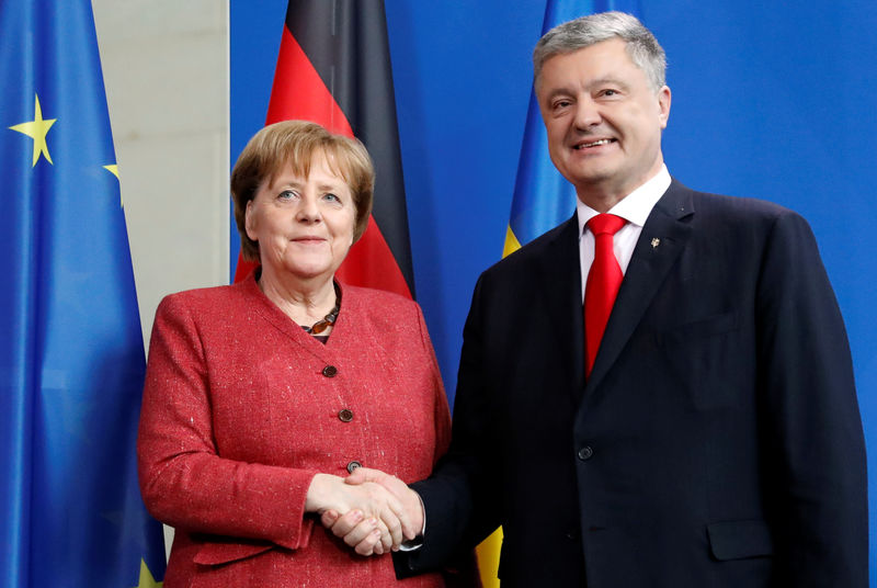 © Reuters. German Chancellor Angela Merkel and Ukrainian President Petro Poroshenko shake hands after a joint news conference in Berlin