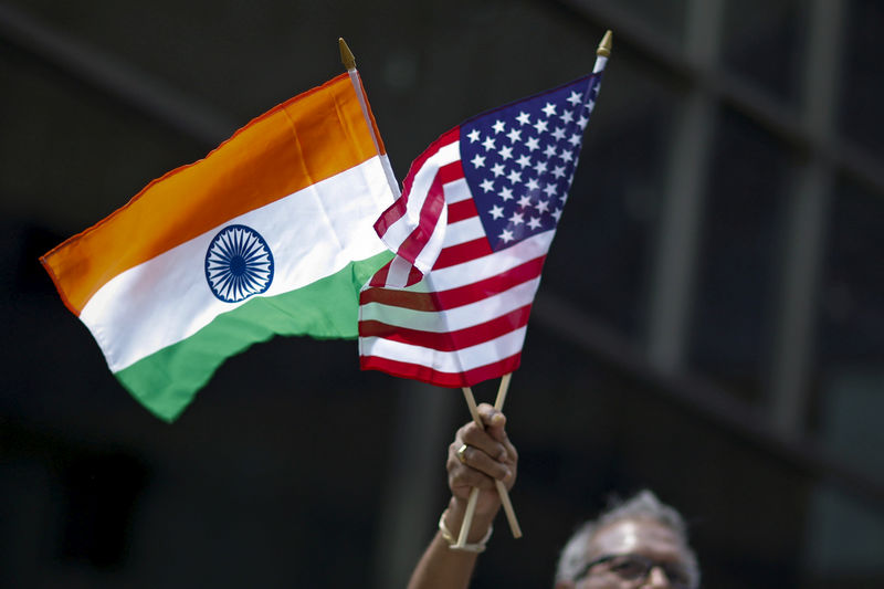 © Reuters. FILE PHOTO: Man holds the flags while people take part in the 35th India Day Parade in New York