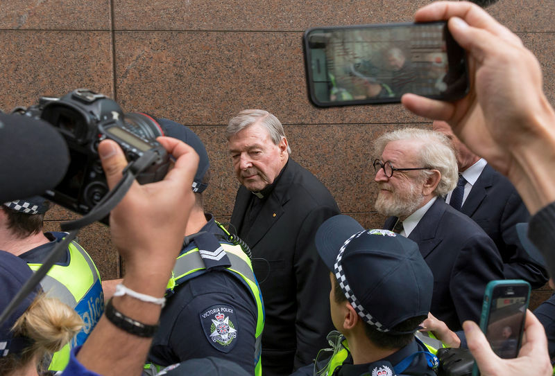 © Reuters. FILE PHOTO - Vatican Treasurer Cardinal George Pell is surrounded by Australian police and members of the media as he leaves the Melbourne Magistrates Court in Australia