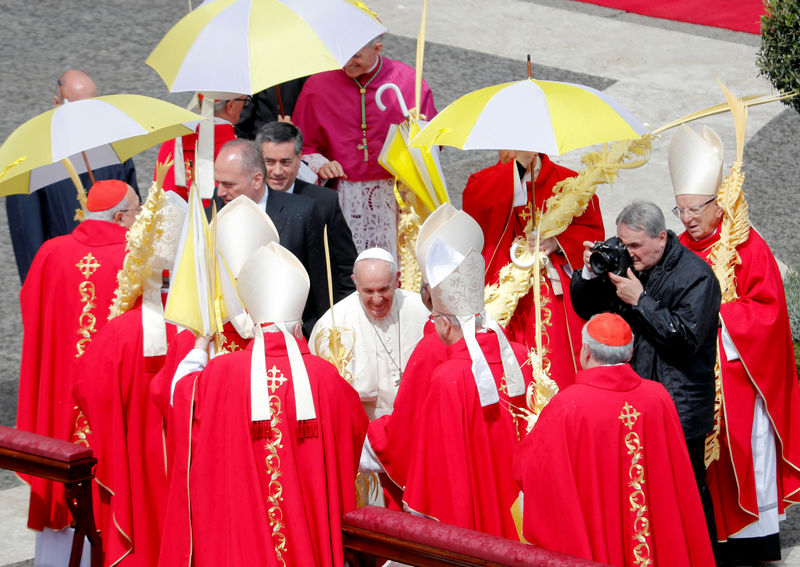 © Reuters. El Papa Francisco saluda a un grupo de cardenales en el final de la misa de Domingo de Ramos en la Plaza de San Pedro, en el Vaticano.