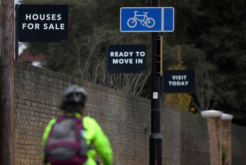 © Reuters. FILE PHOTO: Property sale signs are seen outside of a group of newly built houses in west London