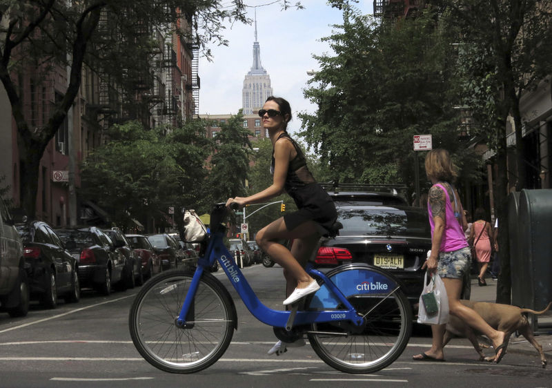 © Reuters. FILE PHOTO: The Empire State Building is seen in the distance as a woman rides a Citibike in the Soho neighbourhood of New York