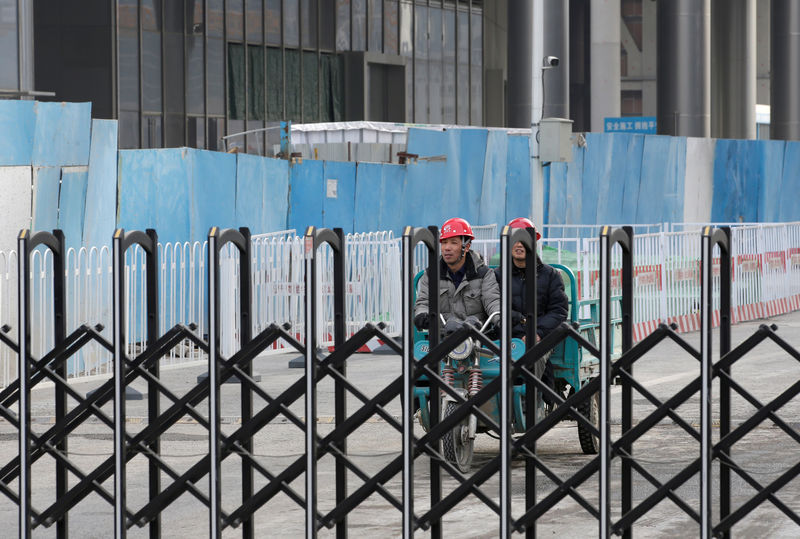 © Reuters. FILE PHOTO: Workers are seen at a construction site in Beijing's central business area