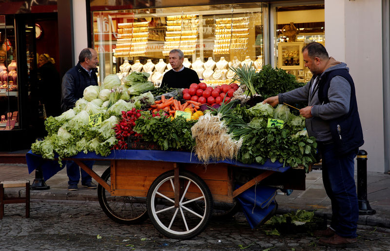 © Reuters. FILE PHOTO: A street vendor stands next to his stall in front of a jewellery shop in Istanbul