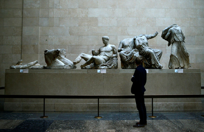 © Reuters. FILE PHOTO: A man looks at the Parthenon Marbles, a collection of stone objects, inscriptions and sculptures, also known as the Elgin Marbles, on show at the British Museum in London