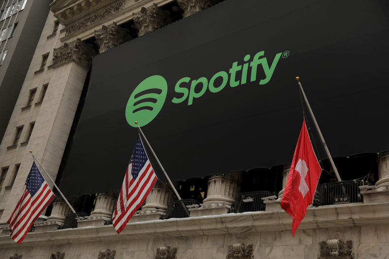 © Reuters. The Spotify logo hangs on the facade of the New York Stock Exchange with U.S. and a Swiss flag as the company lists it's stock with a direct listing in New York