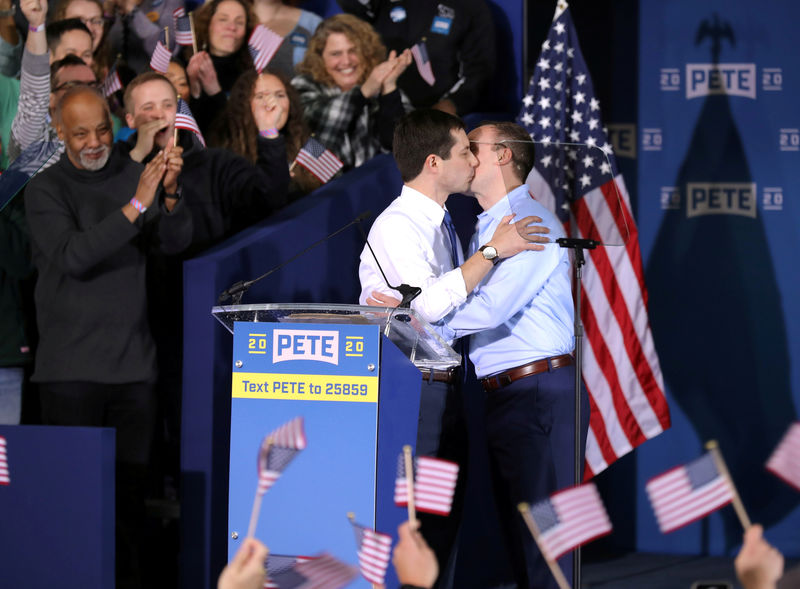 © Reuters. South Bend's Mayor Pete Buttigieg and his husband Chasten Buttigieg kiss as they attend a rally to announce Pete Buttigieg's 2020 Democratic presidential candidacy in South Bend