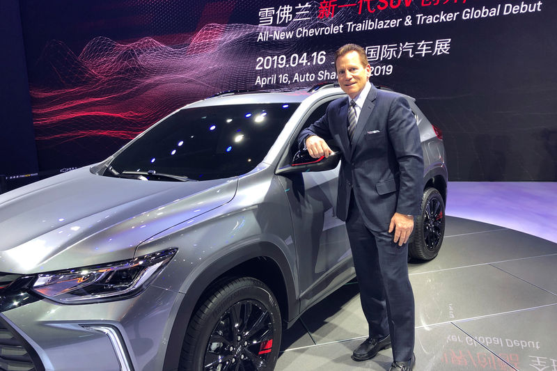 © Reuters. Doug Houlihan, chief engineer of GEM project, poses for photo next to GM's Chevrolet Tracker unveiled at the Shanghai auto show