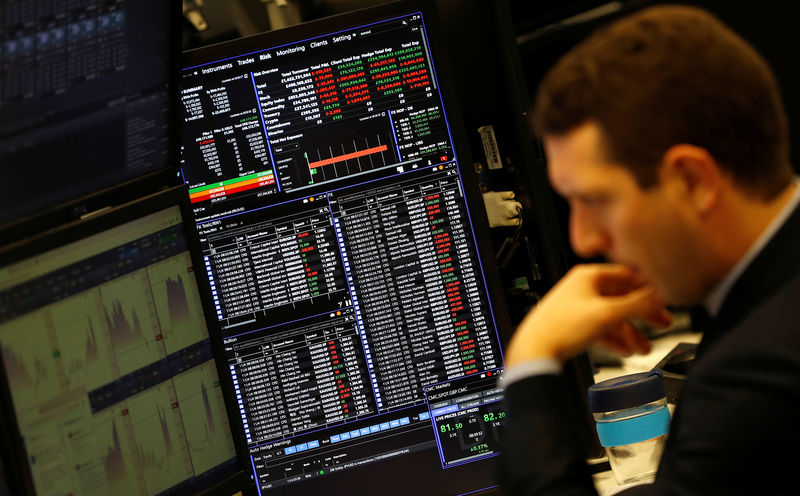 © Reuters. A financial trader works at their desk at CMC Markets in the City of London