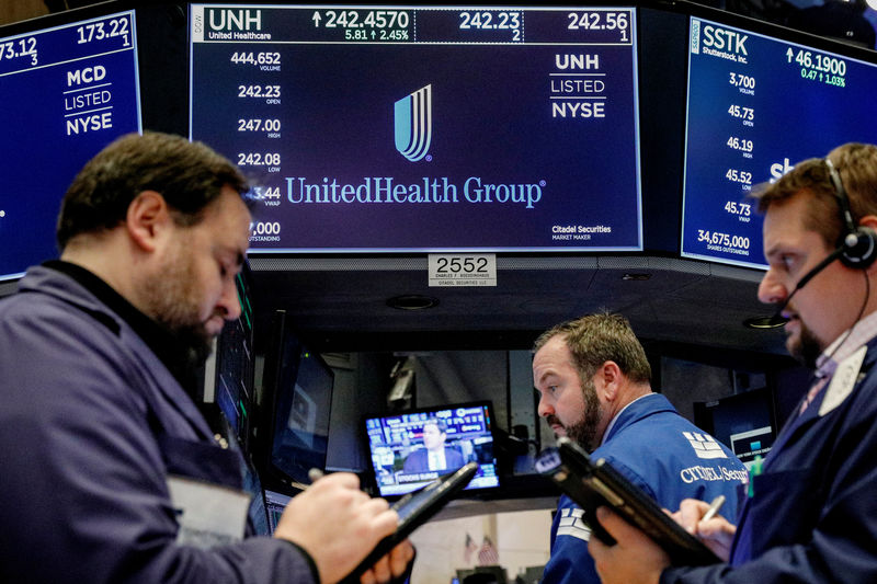 © Reuters. FILE PHOTO: Traders work at the post where UnitedHealth Group is traded on the floor of the NYSE in New York
