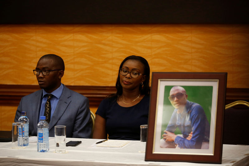 © Reuters. Tom Kabau and Esther Kabau-Wanyoike the brother and sister of Kenyan George Kabau who died in the Ethiopian Airlines crash sit next to his picture during a news conference where their lawyers announced they plan to file a wrongful-death lawsuit against