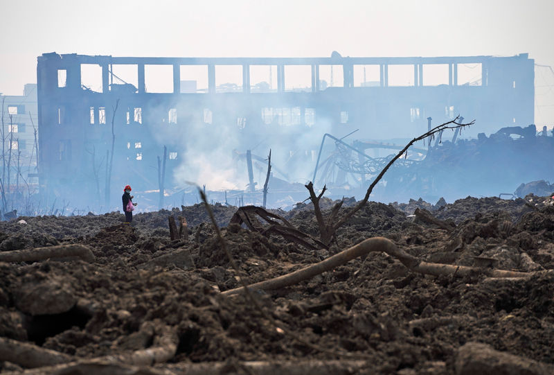 © Reuters. FILE PHOTO: A woman walks at the site at the pesticide plant owned by Tianjiayi Chemical following an explosion, in Xiangshui county