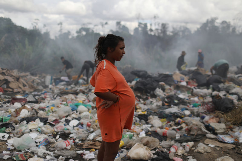 © Reuters. La venezolana Astrid Prado, con 8 meses de embarazo, en un depósito de basura en la ciudad fronteriza brasileña de Pacaraima
