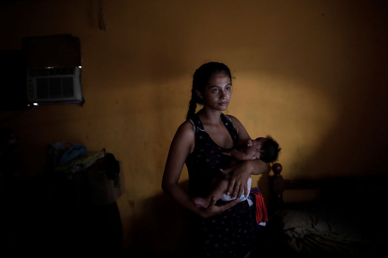 © Reuters. Reina Peley de 20 años fotografiada junto a su hija en su casa de Maracaibo, Venezuela.