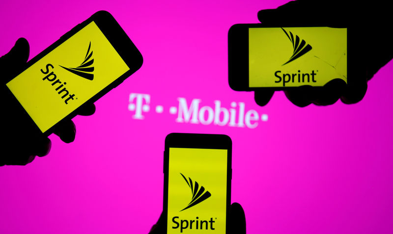 © Reuters. FILE PHOTO: A smartphones with Sprint logo are seen in front of a screen projection of T-mobile logo, in this picture illustration