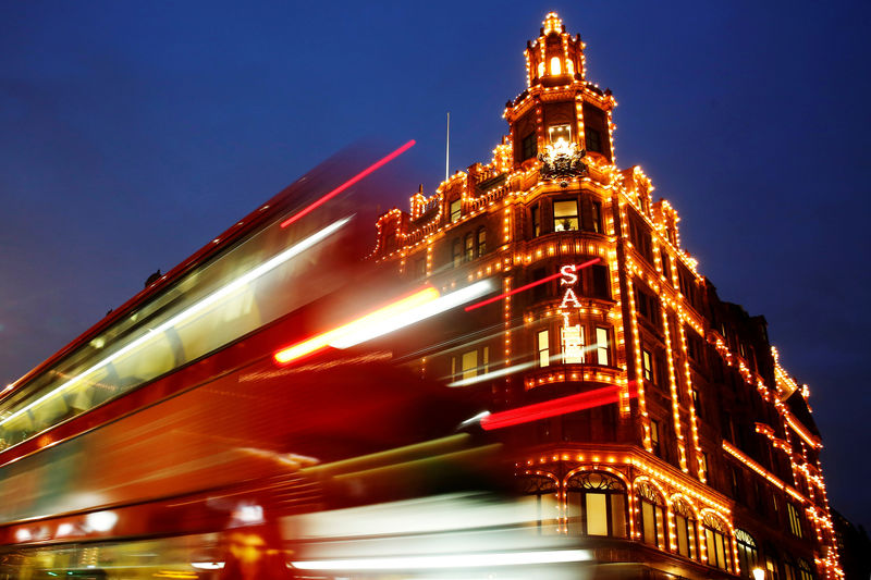 © Reuters. FILE PHOTO: A bus casts light trails as it passes iconic store Harrods in London