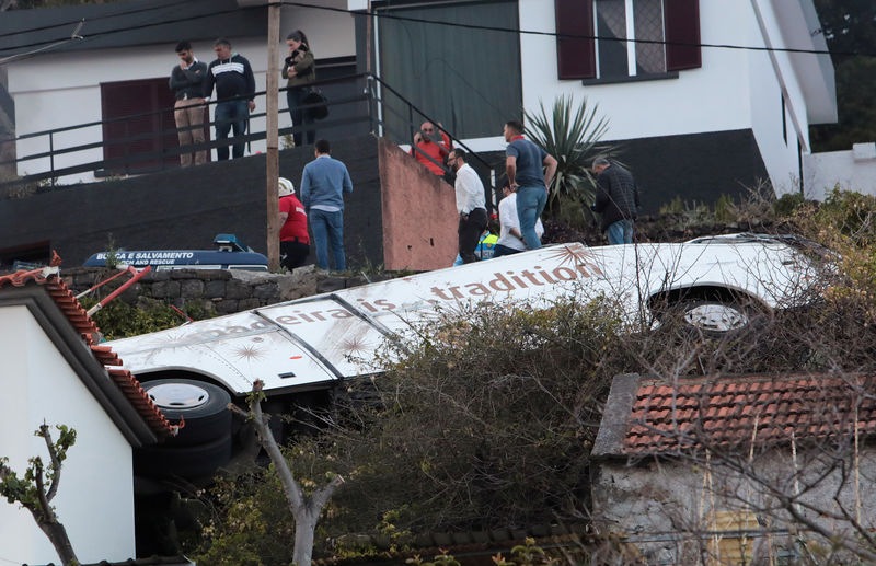 © Reuters. Pessoas observam ônibus que sofreu acidente na Ilha da Madeira, em Portugal