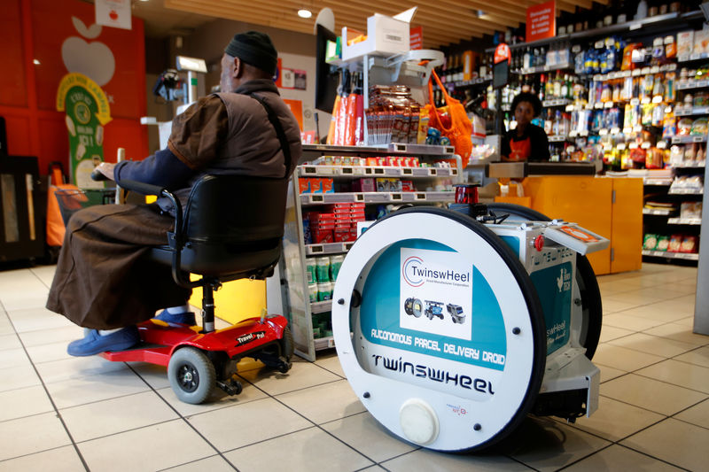 © Reuters. Homem fazendo compras com assistência de robô em Paris