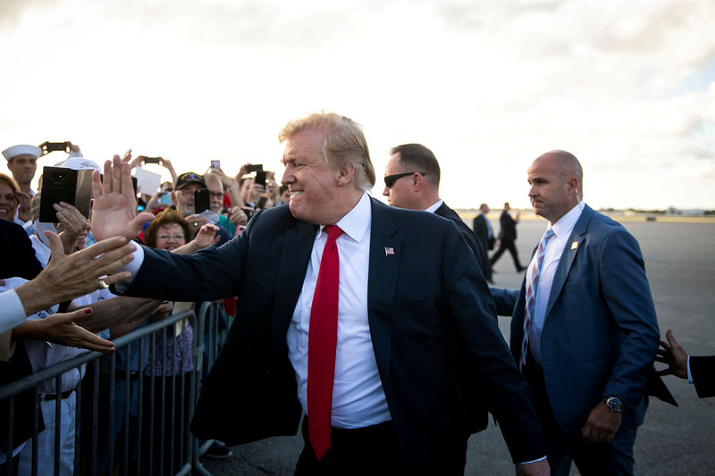© Reuters. U.S. President Donald Trump greets supporters on the tarmac at Palm Beach International Airport, as he arrives to spend Easter weekend at his Mar-a-Lago club, in West Palm Beach